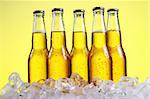 Bierflaschen kalt und frisch mit Eis auf gelbem Hintergrund