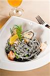 fresh seafood black squid ink coulored spaghetti pasta typical italian food