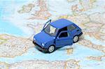 Tiny blue car model on the map of europe