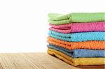 Lots of colorful bath towels stacked on each other. Isolated