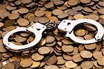 Hand cuffs and coins as security concept