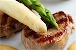 closeup of white and green asparagus on a slice of fillet