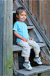 Cute 2 years old boy sitting on the the steps in the park