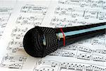 A black microphone on the top of music sheets
