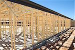 New residential construction home framing against a blue sky