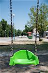 Empty green swing with chain. Vertical image