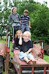 Four children playing on an old tractor