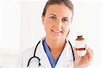 Portrait of a smiling doctor holding some pills in the surgery