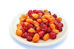 Dried red and yellow cherries in plate isolated on white background.