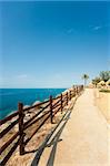 Scenic footpath winding atop a cliff above the Mediterranean