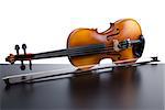 Violin on top of dark table partially isolated on white background.