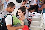 Young lady holding underwear in front of man in laundromat