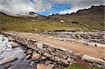 Small lake in high mountain during summer with a bed of stones