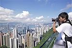 Tourist taking photo of Hong Kong skyline by his digital camera