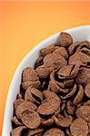 Chocolate cereals on a gradient orange and yellow background.