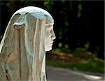 Stone profile of a beautiful young woman in the park in summer