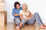 Lovely couple toasting while sitting on the floor