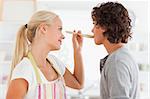 Blonde woman making her fiance tasting her meal while looking at him