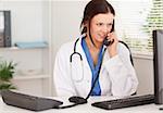 A female doctor is telephoning in her office