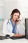 A female doctor is telephoning and looking to the camera