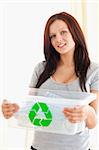 Gorgeous woman holding a recycling box in a living room