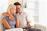 Cute couple watching TV in their living room