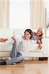 Portrait of a smiling couple watching TV in their living room