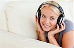 Blonde woman enjoying some music while looking at the camera