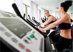 Young athletic couple spinning on veloargometar in gym, looking at each other