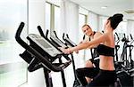 Athletic couple spinning veloargometers in gym, having fun