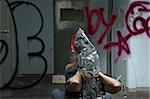 Distorted man emerging through broken glass mirror in abandoned interior.