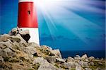 Lighthouse on rocks with light beams