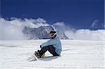 Snowboarder resting on the ski slope. Caucasus Mountains, Dombay