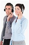 Portrait of operators speaking through headsets against a white background