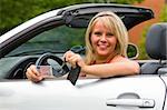 Young female showing her car key into the camera