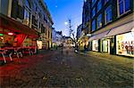 A shopping street with christmas decorations at dusk