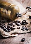 Old fashion coffee mill and coffee beans on and old sack