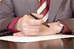 businessman hands on desk signing a document