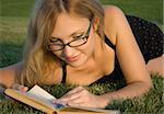 Young woman reading or studying book outdoors