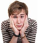 Bored young man with hands on face over white background