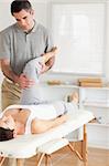 Chiropractor and patient doing exercises in a room