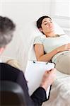 Psychologist talking to a female patient in a room