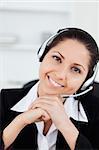A smiling operator sitting with a headset in her office