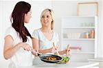 Smiling Women cooking dinner in a kitchen