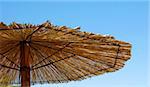 straw umbrella details over blue sky outdoor