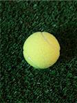 Sporting tennis balls on artificial green grass