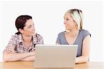 Two pretty women learning with a notebook at a table