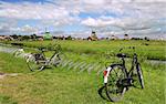 Green fields, creek and windmills in famous Zaanse Schans village near Amsterdam, Netherlands.