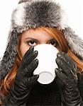 young woman in winter dress drinking coffee or tea from a cup on white background