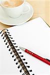 Closeup of Blank Notebook With Ballpoint and Espresso Coffee on Wooden Table